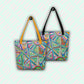 The Geometric Rainbow Tote Bags by My Favourite Colour is Rainbow feature vibrant geometric and heart patterns. One bag boasts yellow straps, the other black, both hanging from hooks.