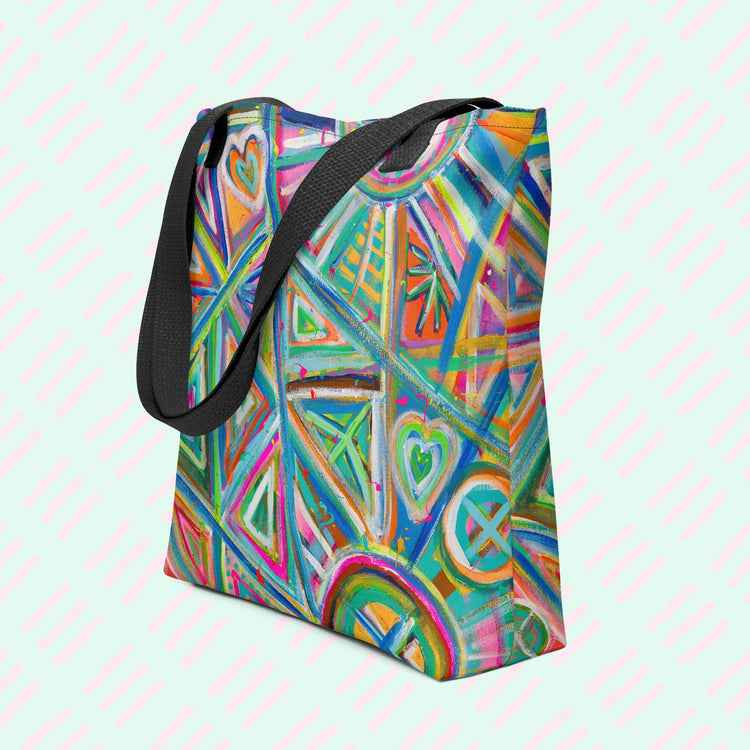 The Geometric Rainbow Tote Bag by My Favourite Colour is Rainbow features vibrant blue, green, orange, pink, and yellow geometric and heart patterns. This version has a black strap.