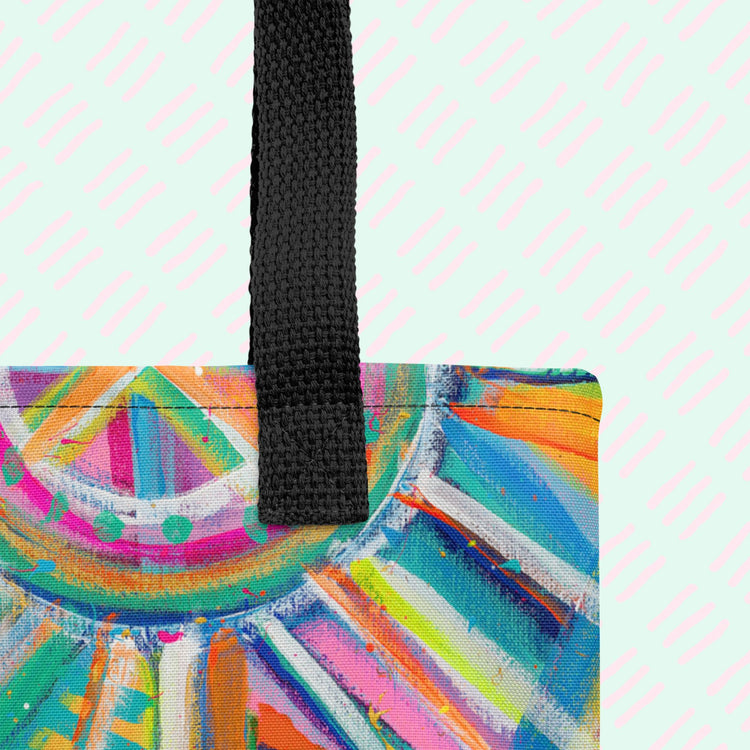 A close-up of the Geometric Rainbow Tote Bag by My Favourite Colour is Rainbow showing the sturdy black strap and part of the colourful, abstract design.