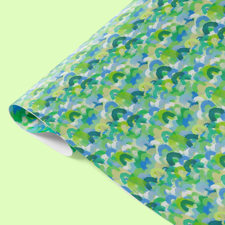 The Green Rainbow Wrapping Paper by My Favourite Colour is Rainbow features an abstract pattern of watercolour brushstrokes resembling rainbows, in shades of green and blue.