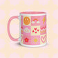 The Happy Smiles Sunny Days Mug by My Favourite Colour is Rainbow is a ceramic gem with a pink handle and a joyful pattern of smiley faces, rainbows, and hearts on a soft pink backdrop.