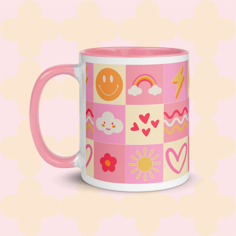 The Happy Smiles Sunny Days Mug by My Favourite Colour is Rainbow is a ceramic gem with a pink handle and a joyful pattern of smiley faces, rainbows, and hearts on a soft pink backdrop.