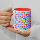 A person in a white shirt holds the Heart Attack Mug by My Favourite Colour is Rainbow, featuring a red interior and handle with a vibrant, multicoloured heart pattern.