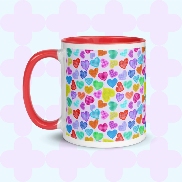 The Heart Attack Mug by My Favourite Colour is Rainbow features a red interior and handle, with a vibrant pattern of overlapping hearts in bright blue, purple, yellow, and pink on a pastel background.