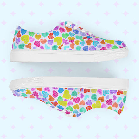 Side views of the Heart Attack Canvas Sneakers by My Favourite Colour is Rainbow, decorated with a colourful heart pattern on a light background. Displayed side by side, they showcase a vibrant, playful design and a comfy fit.