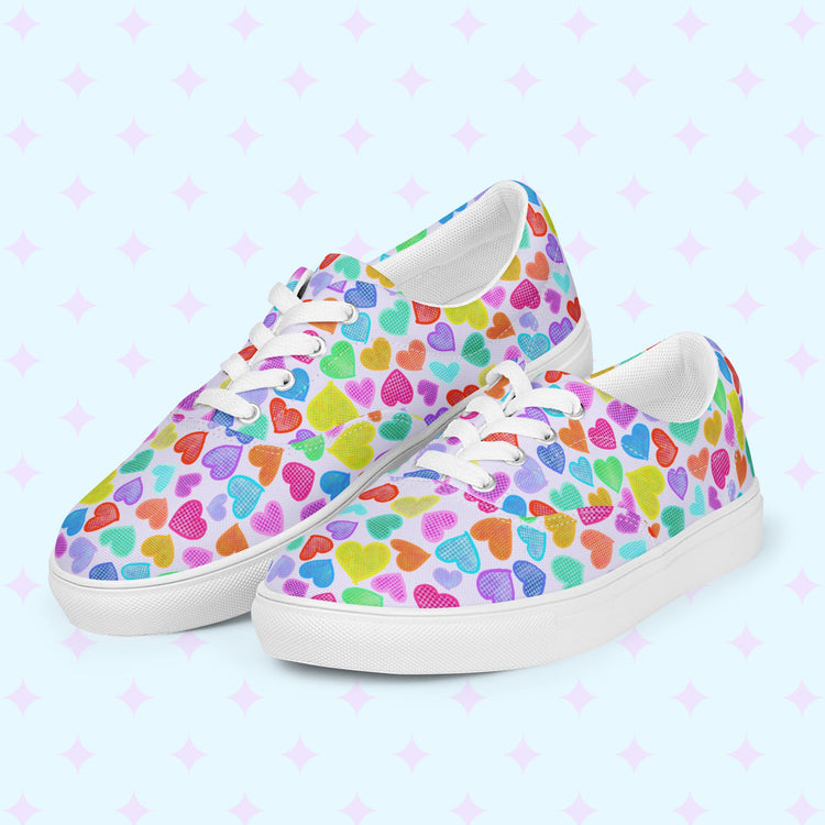 My Favourite Colour is Rainbows Heart Attack Canvas Sneakers feature a vibrant heart print in blue, green, pink, orange, and purple on a light background. Complete with white laces and soles, these sneakers offer style and comfort.