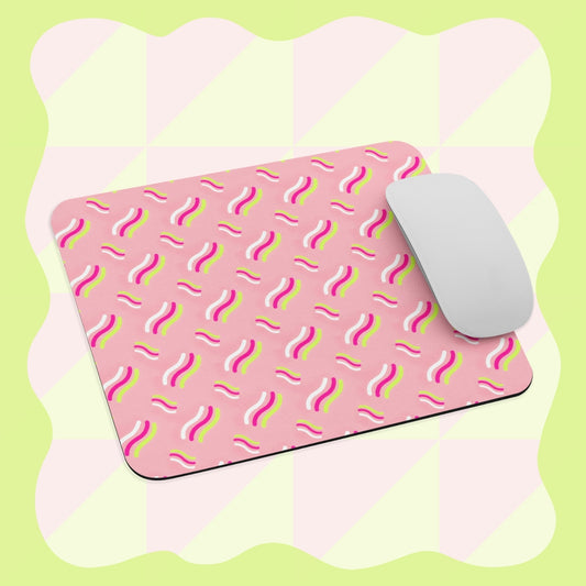 A white computer mouse sits on the Iced Vovo Mouse Pad by My Favourite Colour is Rainbow, featuring wavy, multicolored lines. The background displays a light green and cream checkerboard pattern with wavy edges.