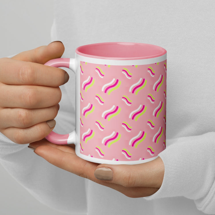 Hands holding the Iced Vovo Mug from My Favourite Colour is Rainbow, featuring a stylised design inspired by the famous Aussie biscuit, with wavy green, pink, and white lines. The mug has a light pink interior and handle and is being held by a woman wearing a white sweater.