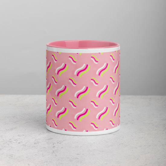 The Iced Vovo Mug by My Favourite Colour is Rainbow features a pink ceramic design with wavy lines in white, green, and pink set.