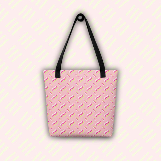 The Iced Vovo Tote Bag by My Favourite Colour is Rainbow is a spacious tote with black handles, a pink backdrop, and an abstract pattern reminiscent of the famous biscuit with white, pink and lime green wavy line patterns. 