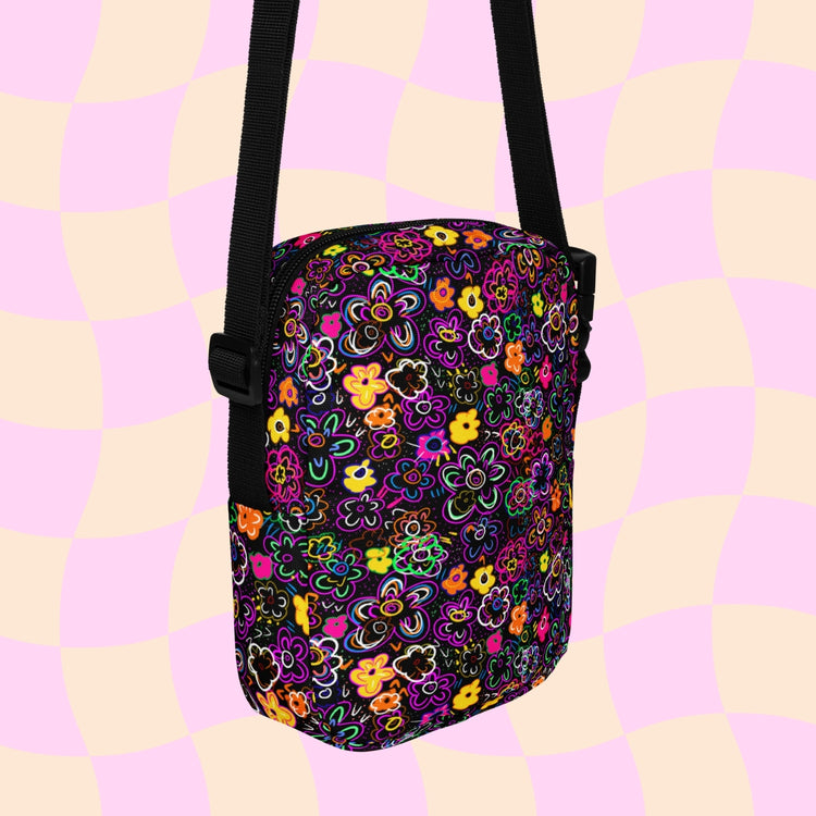 The In the Midnight Garden Mini Crossbody Bag by My Favourite Colour is Rainbow features a vibrant, multicoloured floral print on black canvas, an adjustable strap for comfort, and external and internal pockets.