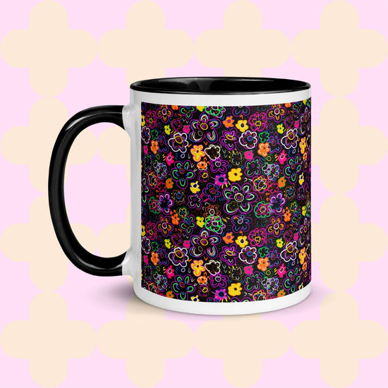 The In the Midnight Garden Mug by My Favourite Colour is Rainbow features a colourful floral pattern of pink, yellow, green, and purple hand-drawn flowers on a black background. It has a black handle and interior.