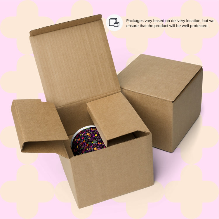 An open cardboard box reveals a glimpse of the In the Midnight Garden Mug by My Favourite Colour is Rainbow, with another closed box nearby. A note mentions packaging varies by location but regardless will ensure product protection.