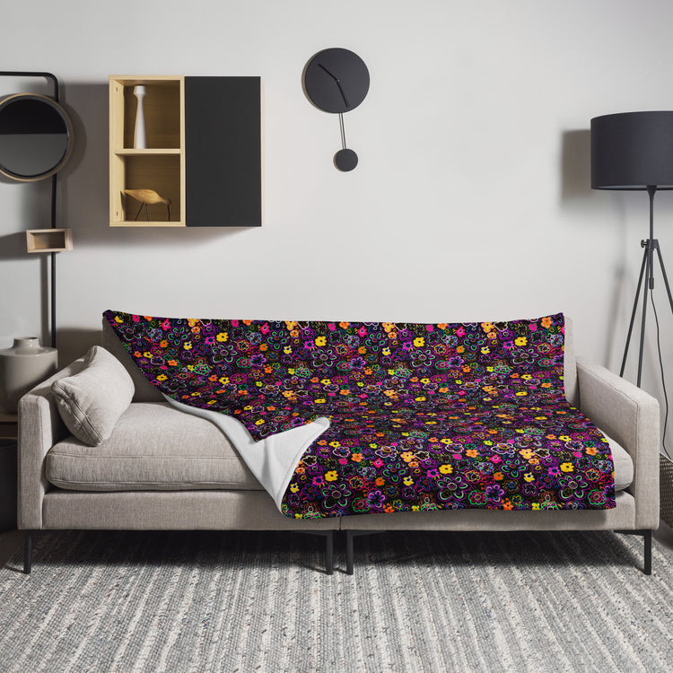 A modern living room showcases a light gray sofa adorned with the In the Midnight Garden Throw Blanket by My Favourite Colour is Rainbow. The space features a black floor lamp, round wall clock, and wall-mounted shelving. A gray textured rug completes the cosy fabric feel underfoot.