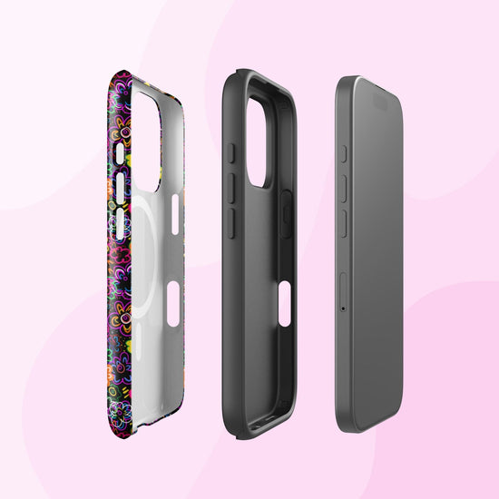 Three iPhone cases are arranged on a pink background. The first, called In the Midnight Garden, features a floral design from My Favourite Colour is Rainbow. The second is plain black with dual-layer protection, and the third is gray with minimal buttons. Each case stands upright and slightly angled.