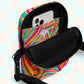 The Karma Kaleidoscope Mini Crossbody Bag by My Favourite Colour is Rainbow features a lively pattern of bold pink, orange, blue, and green swirls and geometric shapes. It is shown open, revealing an iPhone in the internal pocket, which has a small My Favourite Colour is Rainbow.  The bag is made of canvas-type material, has internal and external pockets and an adjustable black strap with a buckle on one side that can be extended to crossbody length.
