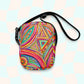 Discover the Karma Kaleidoscope Mini Crossbody Bag by My Favourite Colour is Rainbow, featuring a lively pattern of bold pink, orange, blue, and green swirls and geometric shapes. It is made of canvas-type material, has internal and external pockets and an adjustable black strap with a buckle on one side that can be extended to crossbody length.