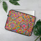 The 15 inch Love in Neon Laptop Sleeve by My Favourite Colour is Rainbow features a vibrant design of multicoloured flowers, hearts and sun. It rests on a grey surface next to green leaves with a laptop partially inside.