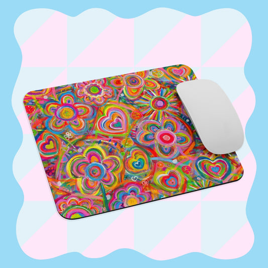 The Love in Neon Mouse Pad by My Favourite Colour is Rainbow features an abstract, vibrant heart and swirl design with a white mouse on top. The background has a wavy blue and pink checkered pattern.