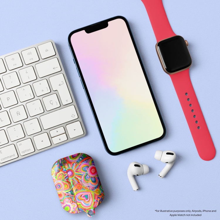 A pastel-themed workspace displays an impact-resistant smartphone case, a keyboard, an Apple Watch with a red band, and a Love in Neon AirPods Pro Case with bright florals on a light blue surface.