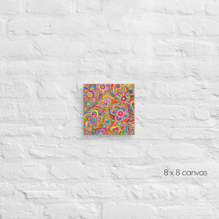 The Love in Neon Canvas Artwork by My Favourite Colour is Rainbow bursts with psychedelic swirls and heart shapes on an 8x8 canvas, creating a mesmerizing display against the textured white brick wall.