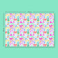 The Multicolour Bow Birthday Wrapping Paper Sheets by My Favourite Colour is Rainbow features bows, ribbons, and Happy Birthday in pink, orange, green, and blue on a light green background. The image measures 707mm by 500mm and is set against a turquoise backdrop.