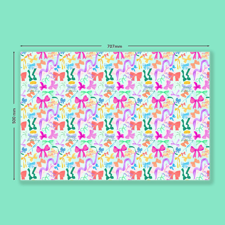 The Multicolour Bow Birthday Wrapping Paper Sheets by My Favourite Colour is Rainbow features bows, ribbons, and Happy Birthday in pink, orange, green, and blue on a light green background. The image measures 707mm by 500mm and is set against a turquoise backdrop.