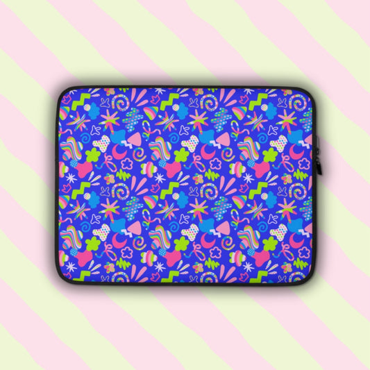 The Neon Carnival Laptop Sleeve by My Favourite Colour is Rainbow features vibrant abstract shapes, lines and doodles in pink, green, blue and white on a bright blue background. The laptop sleeve is shown on a pastel background.  The print is on only one side of the laptop sleeve, the other side is black.