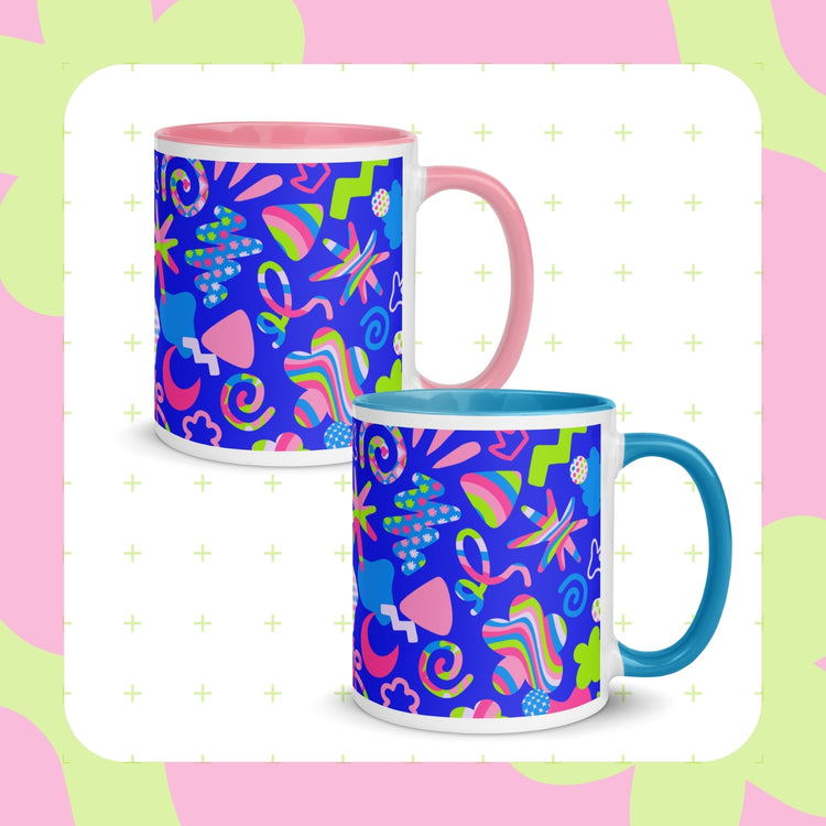 Two Neon Carnival Mugs from My Favourite Colour is Rainbow featuring vibrant abstract patterns of swirls, stars and other doodles on a blue backdrop. 
 One mug has a pink handle/interior and the other has light blue.  The mugs are set against a pastel pink and green background.