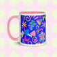 The Neon Carnival Mug by My Favourite Colour is Rainbow features vibrant abstract shapes and doodles in green, blue and white on a blue backdrop.  This version has a light pink handle and interior.