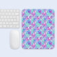 The Pastel Rainbow Mouse Pad by My Favourite Colour is Rainbow, featuring pink, blue, and purple abstract shapes, sits beside a white keyboard and mouse on a light blue surface.