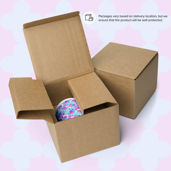 Two cardboard boxes, one displaying a Pastel Rainbow Mug from My Favourite Colour is Rainbow. A closed box sits nearby on a pastel, geometric background. A message indicates that packaging may vary by delivery location to ensure product protection.