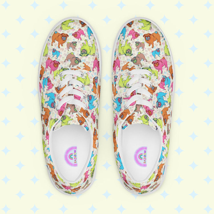 Pugalicious Canvas Sneakers by My Favourite Colour is Rainbow are vivid womens canvas sneakers with cartoon dinosaur patterns, shown from above on a light diamond-patterned background. These lace-up sneakers feature white laces and soles for contrast against the colorful designs.