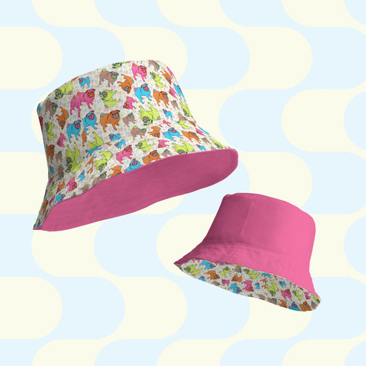 The Pugalicious Reversible Bucket Hat by My Favourite Colour is Rainbow features two breathable designs: one with colorful cartoon animals on white paired with solid pink, and the other showcasing playful patterns against a pastel geometric background, making it an ideal streetwear accessory.