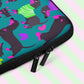 A close-up of the Silly Sausages Laptop Sleeve – Green by My Favourite Colour is Rainbow, featuring playful dachshunds in green and purple on a dark green backdrop with matching coloured hearts. It has a double black zipper and padded zipper binding.  It is shown on a pastel background.  The print is on only one side of the laptop sleeve, the other side is black.