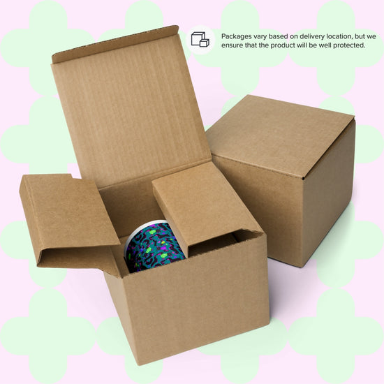 An open cardboard box contains a colourful Silly Sausages Mug by My Favourite Colour is Rainbow, shown next to a closed box. A note states, Packaging for the varies by location, but we ensure product safety.