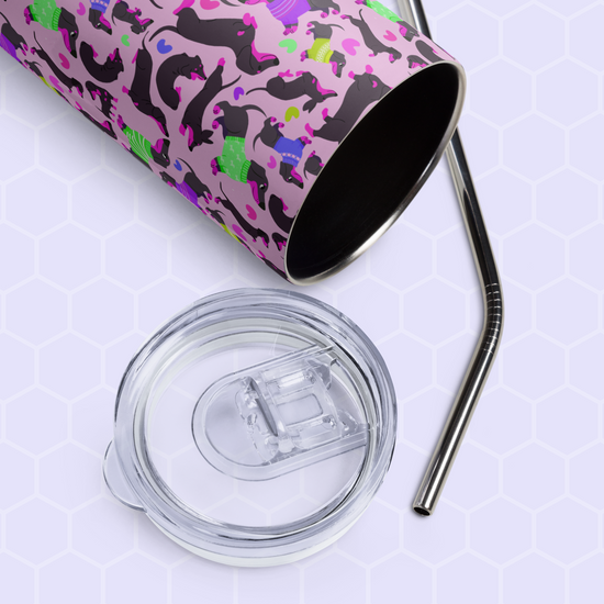 The Silly Sausages Stainless Steel Tumbler by My Favourite Colour is Rainbow, featuring a colorful cat pattern, lies on its side with a metal straw and clear plastic lid. Its stainless steel ensures durability, while the light hexagonal background adds style.