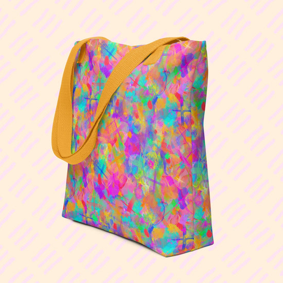 The Splotches and Crosses Tote Bag by My Favourite Colour is Rainbow features an abstract pattern of pink, blue, green, and orange splashes.  This version has yellow straps.