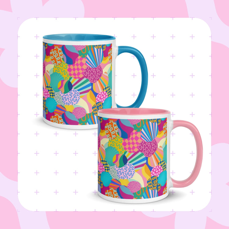 Two Squiggs and Stripes mugs by My Favourite Colour is Rainbow featuring vibrant geometric designs. One mug has a blue handle, the other a pink.  The mugs are set against a soft pink and white patterned background. 