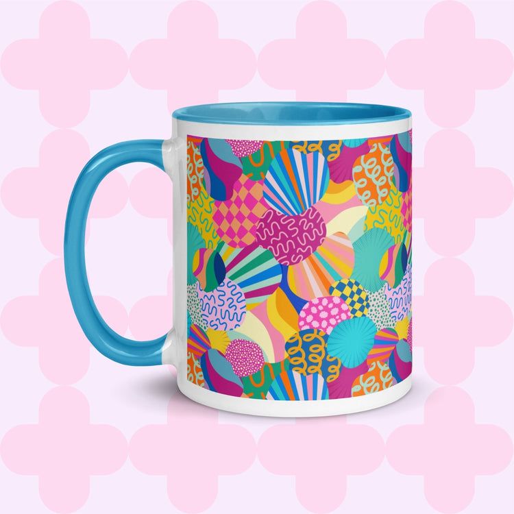 The Squiggs and Stripes Mug by My Favourite Colour is Rainbow features a white base with a vibrant abstract design of shapes and swirls in pink, yellow, blue, and green. A blue handle and interior adds contrast.