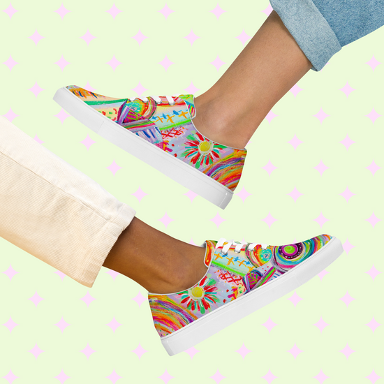 Two people sport Summer Sorbet Canvas Sneakers from My Favourite Colour is Rainbow, featuring swirls and geometric patterns. Against a light green backdrop with pink diamonds, they wear rolled-up beige and light blue pants, capturing the essence of Summer Sorbet vibes.