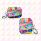 The Rainbow Connection AirPods Case by My Favourite Colour is Rainbow features abstract geometric patterns with rainbow hues of stripes and triangles. Each durable, impact-absorbing case includes a metal keychain ring. Shown on a pink and white geometric background.