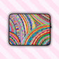 The Rainbow Connection Laptop Sleeve, by My Favourite Colour is Rainbow, features a colourful design with an abstract pattern of curved lines, dots, and triangles in vibrant pink, orange, green, blue, and yellow.