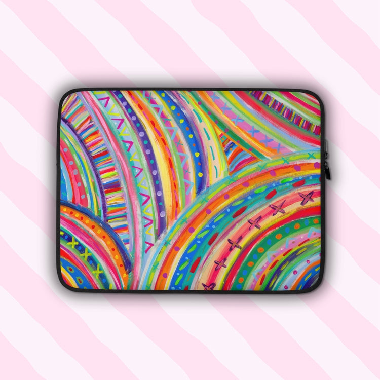 The Rainbow Connection Laptop Sleeve, by My Favourite Colour is Rainbow, features a colourful design with an abstract pattern of curved lines, dots, and triangles in vibrant pink, orange, green, blue, and yellow.