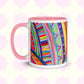 The Rainbow Connection Mug by My Favourite Colour is Rainbow features intricate patterns of stripes, dots, and zigzags in vibrant pink, blue, green, and yellow. It features a pink handle and inner rim .