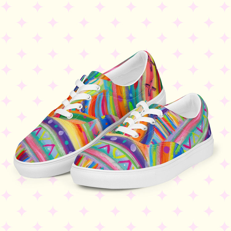 The Rainbow Connection Canvas Sneakers by My Favourite Colour is Rainbow burst with vibrant red, blue, yellow, green, and pink abstract patterns. These canvas sneakers feature white laces and soles.