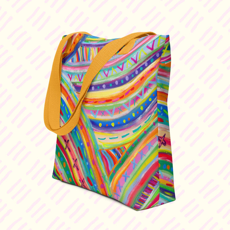 The Rainbow Connection Tote Bag from My Favourite Colour is Rainbow features vibrant abstract patterns in rainbow hues with yellow handles and a spacious design.