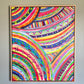 Acrylic on canvas, The Rainbow Connection Framed Original Painting by My Store features swirling arcs with vibrant patterns of stripes, dots, and crosses. Its professionally framed in light wood, creating a standout display against a gray wall.