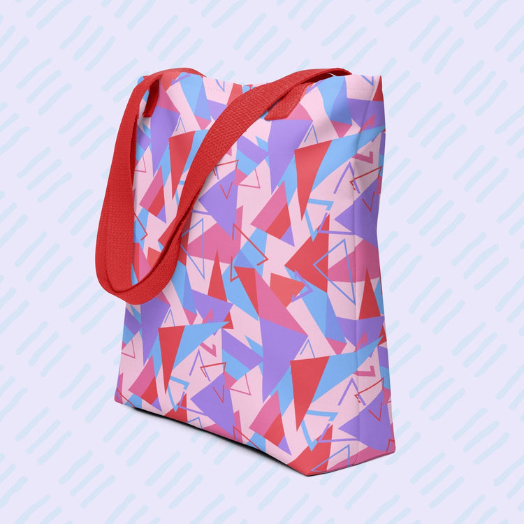 The Tri the Angle Tote Bag by My Favourite Colour is Rainbow features red, purple, blue, and pink triangle patterns with a black handle. 