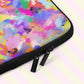 A close-up of the Watercolour Rainbow Laptop Sleeve from My Favourite Colour is Rainbow features a vibrant abstract pattern with pink, purple, blue, yellow, and green splashes of colour.  It includes a black padded binding with dual zipper pull tabs for added convenience.  The print is on only one side of the laptop sleeve, the other side is black. It is shown on a pastel background.